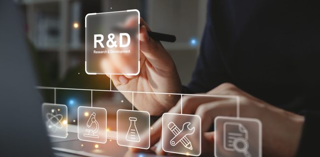 Hand of businessman holding a pen pointing to R and D icon for Research and Development on laptop screen. Manage costs more efficiently. R and D innovation concept.